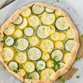 circular shaped pizza with squash as topping with words on top