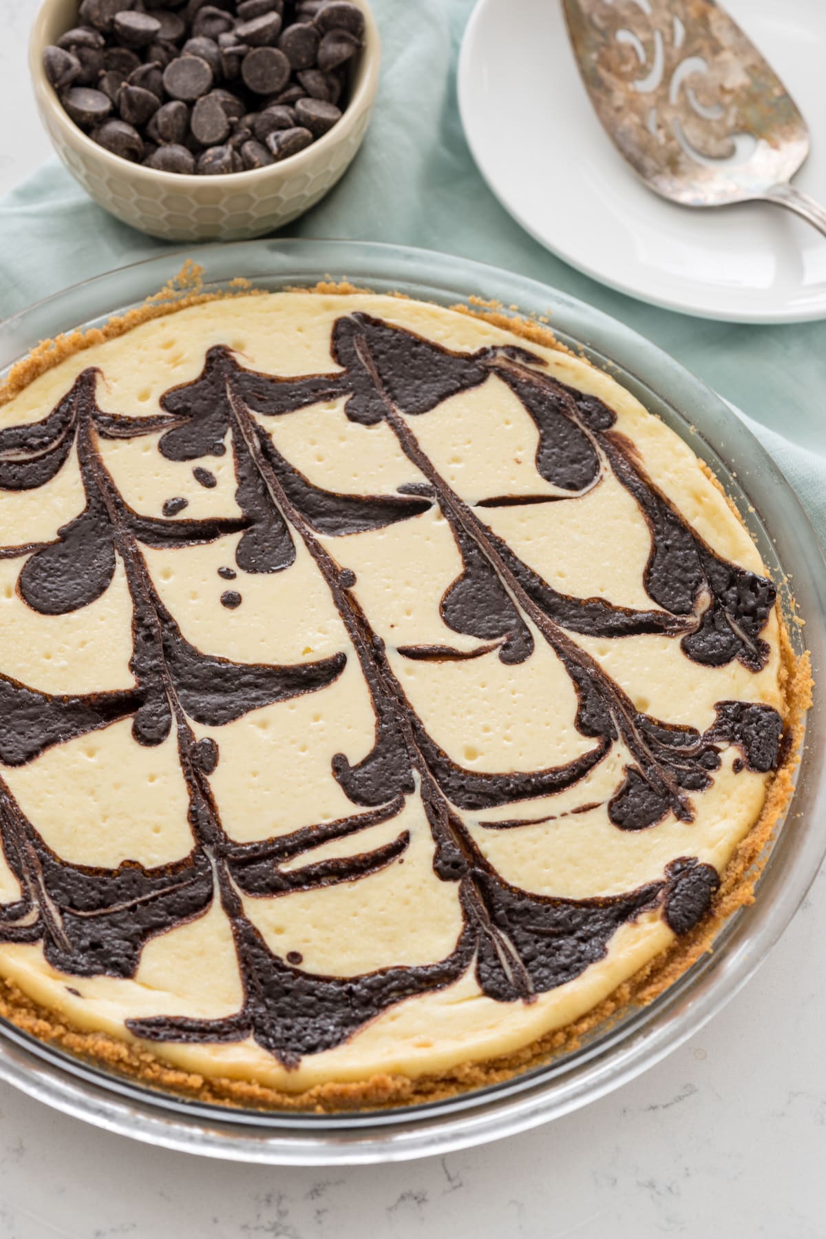 cheesecake pie on a white plate with chocolate dripped over