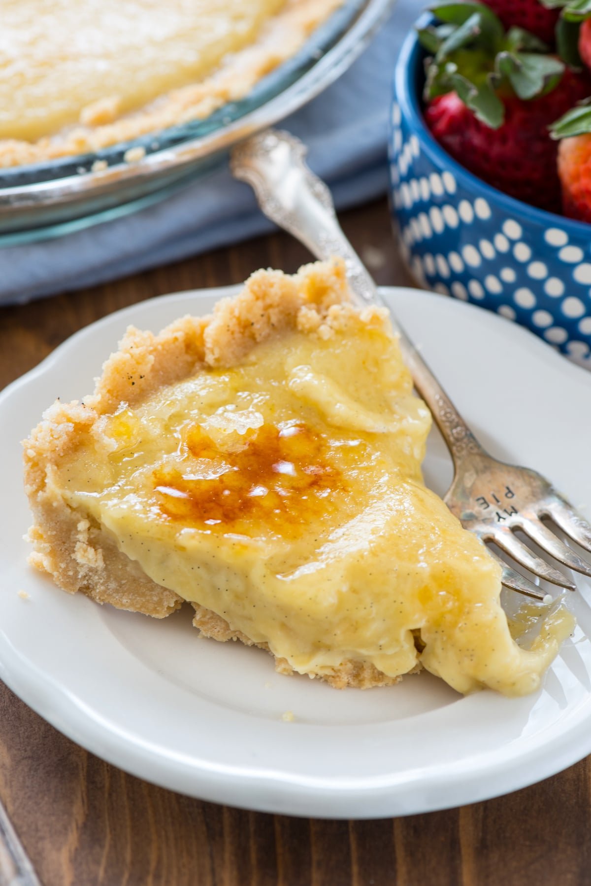 creme brûlée pie on a white plate next to a fork