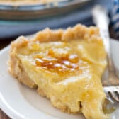 creme brûlée pie on a white plate next to a fork