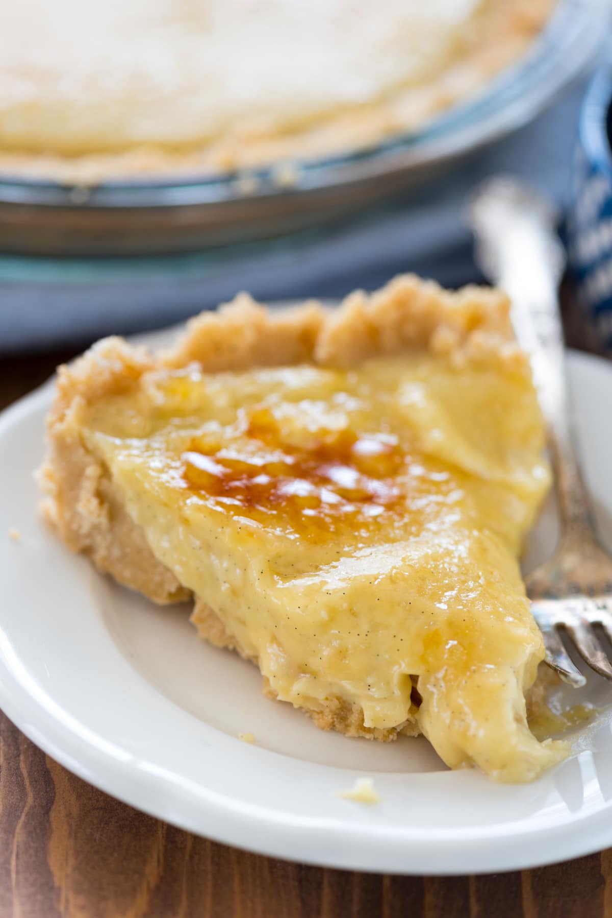 creme brûlée pie on a white plate next to a fork