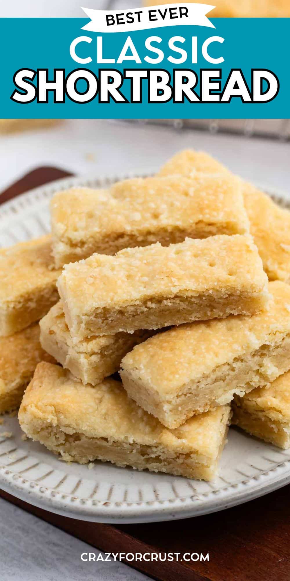 A plate stacked with golden, rectangular pieces of classic shortbread, with a soft, crumbly texture. Text at the top reads Best Ever Classic Shortbread Cookies Recipe.