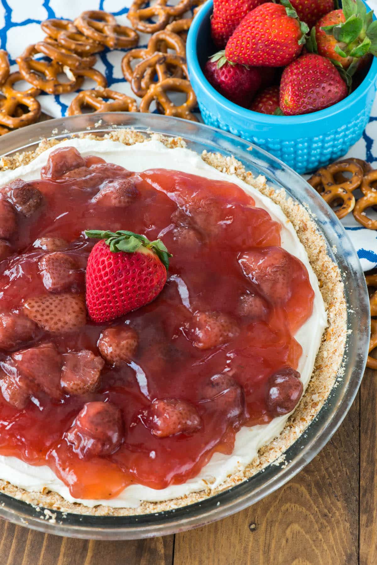 cream cheese pie with strawberry pie filling on top and pretzels around the pie