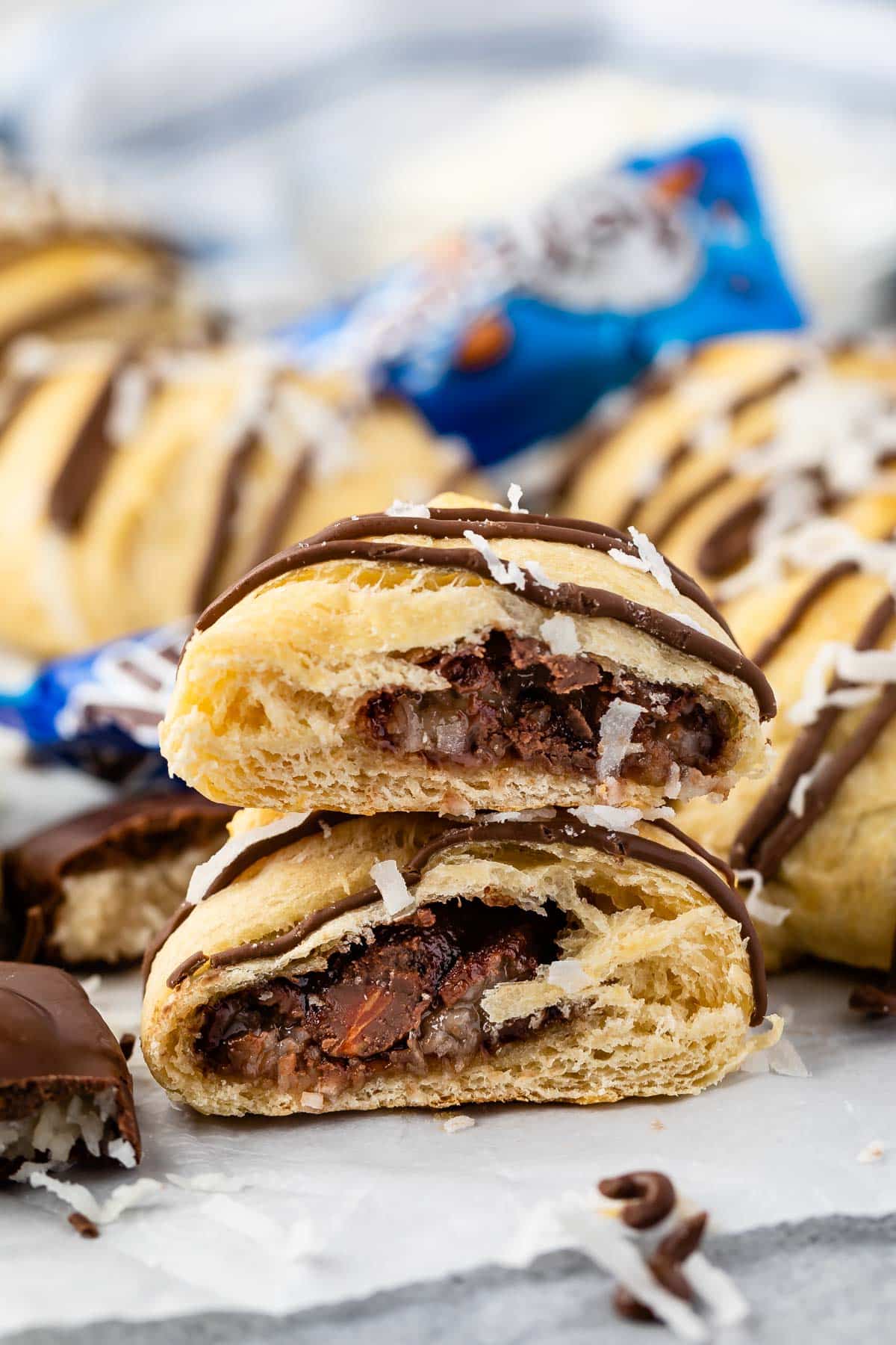 two crescent rolls cut in half showing almond joy chocolate in the middle