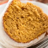 pumpkin bundt cake with frosting on top in a white platter with words on top