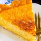 A slice of golden brown buttermilk pie with a flaky crust rests on a white plate, next to a fork engraved with the words MY PIE.