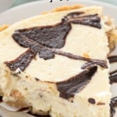 cheesecake pie on a white plate with chocolate dripped with words on the image