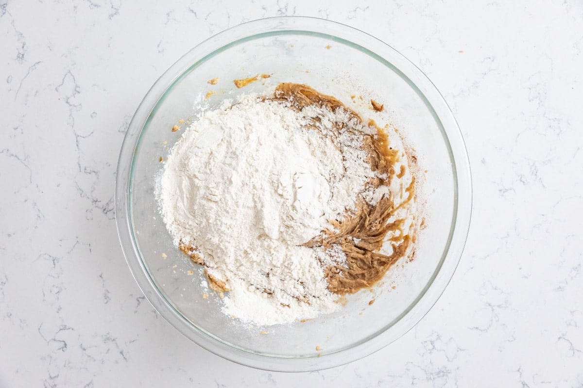 cookie dough with flour in glass bowl.