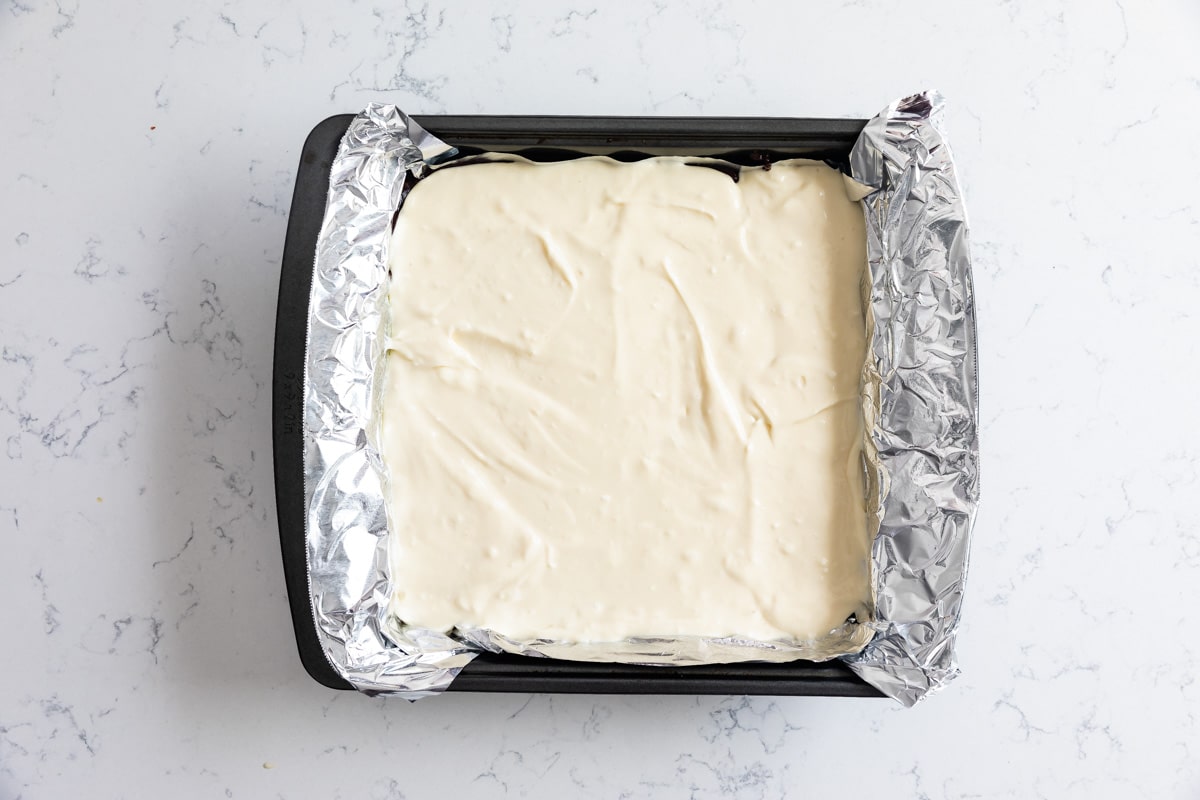 cheesecake batter in square pan with foil.