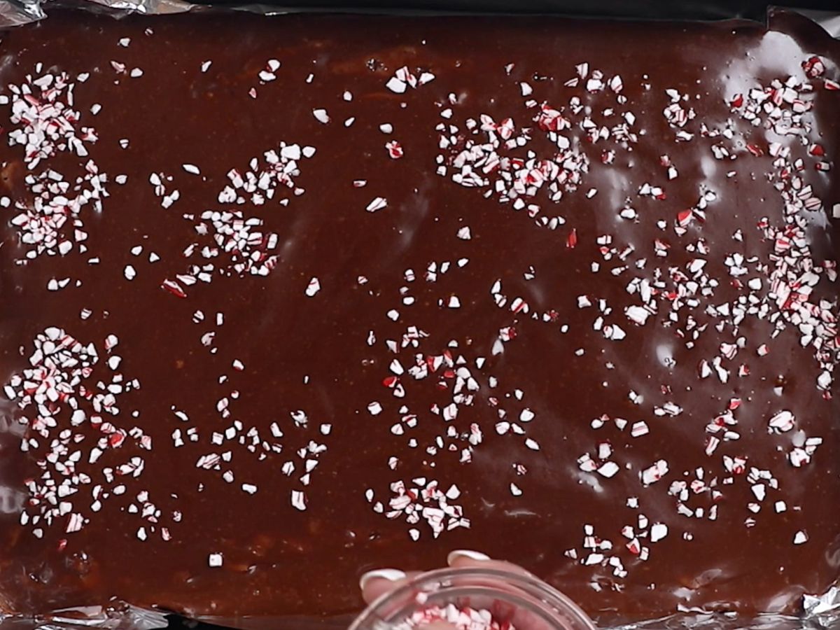 brownies in pan with icing and peppermint pieces.