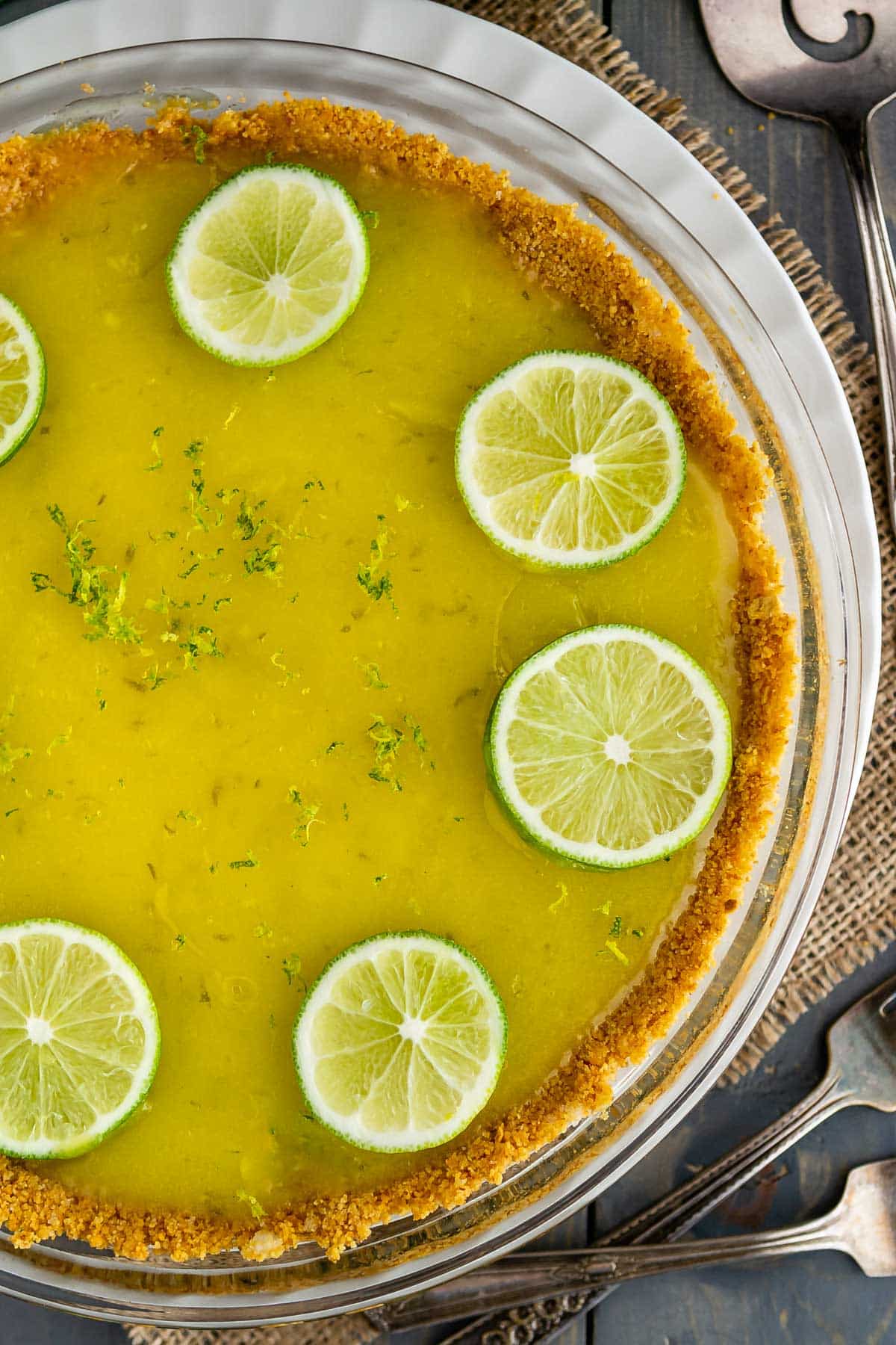 pie with graham cracker crust filled with lime filling and topped with sliced limes