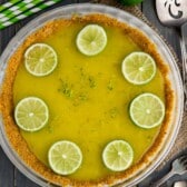 pie with graham cracker crust filled with lime filling and topped with sliced limes