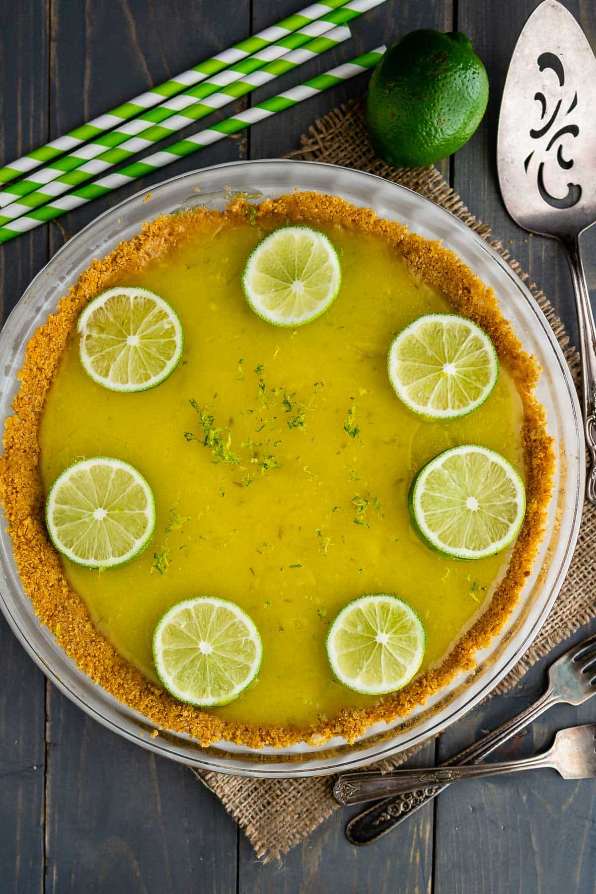 pie with graham cracker crust filled with lime filling and topped with sliced limes