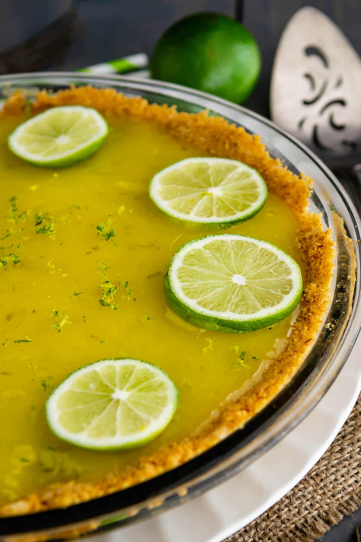 pie with graham cracker crust filled with lime filling and topped with sliced limes