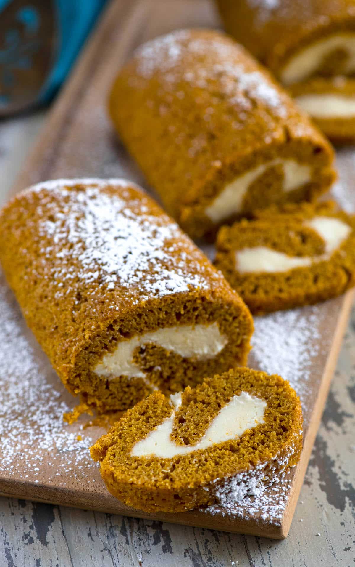 3 pumpkin rolls dusted with powdered sugar on cutting board