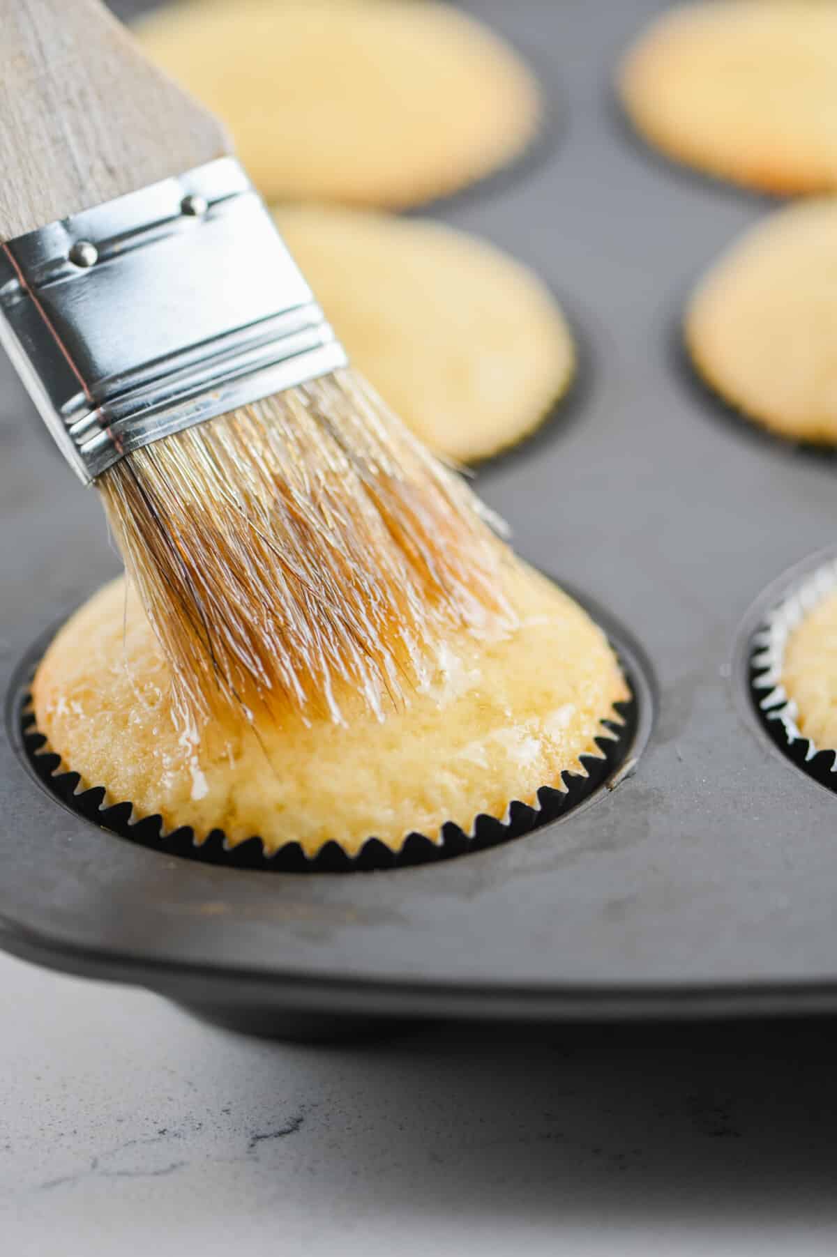 brushing cupcake with glaze