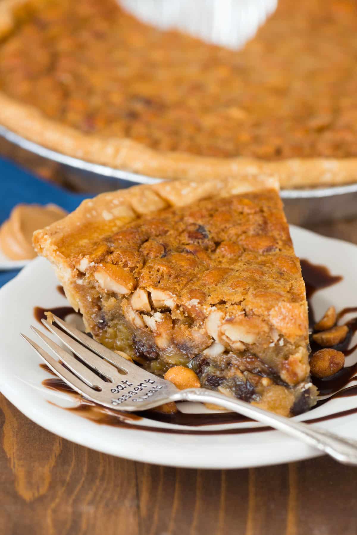 slice of pie on white plate with chocolate sauce underneath