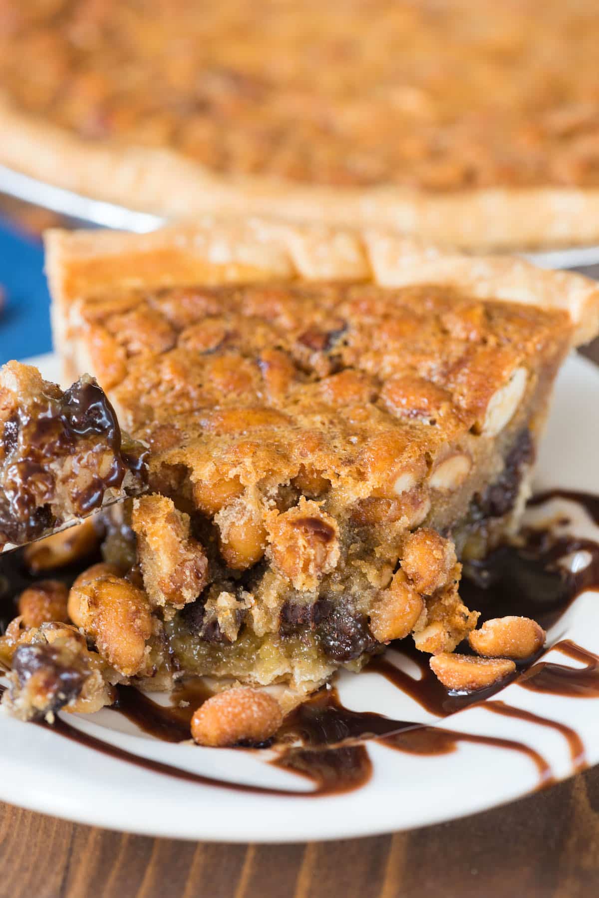 slice of pie on white plate with chocolate sauce underneath