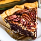 chocolate pecan pie on a white plate next to a fork