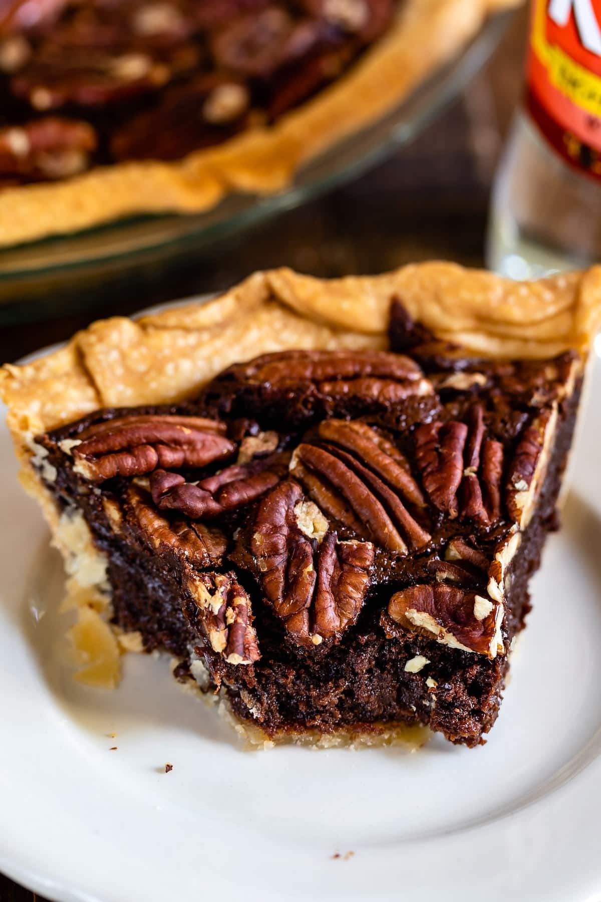 chocolate pecan pie on a white plate next to a fork