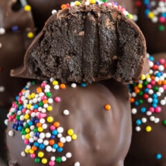 chocolate covered truffled with colorful sprinkles on top in a white bowl