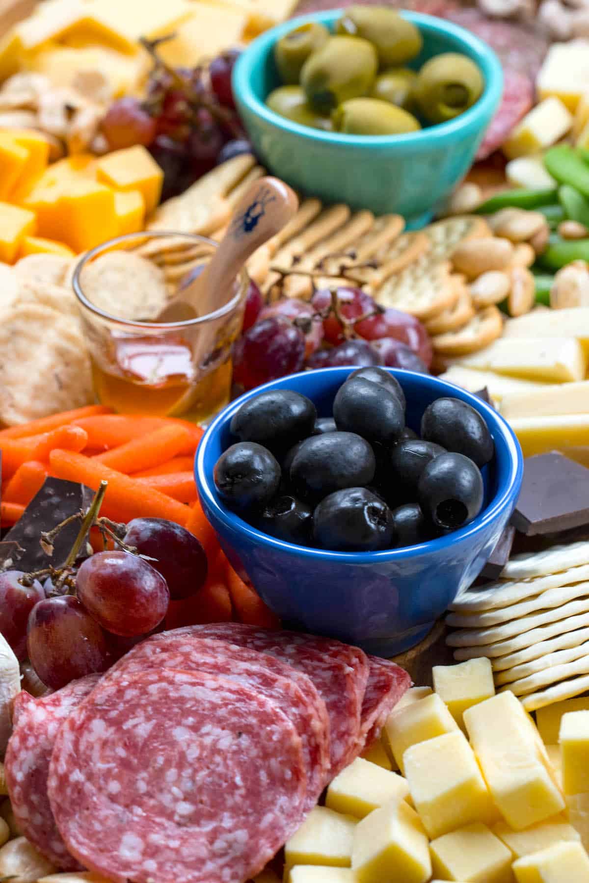 cheese board items laid on a wooden cutting board with words on top