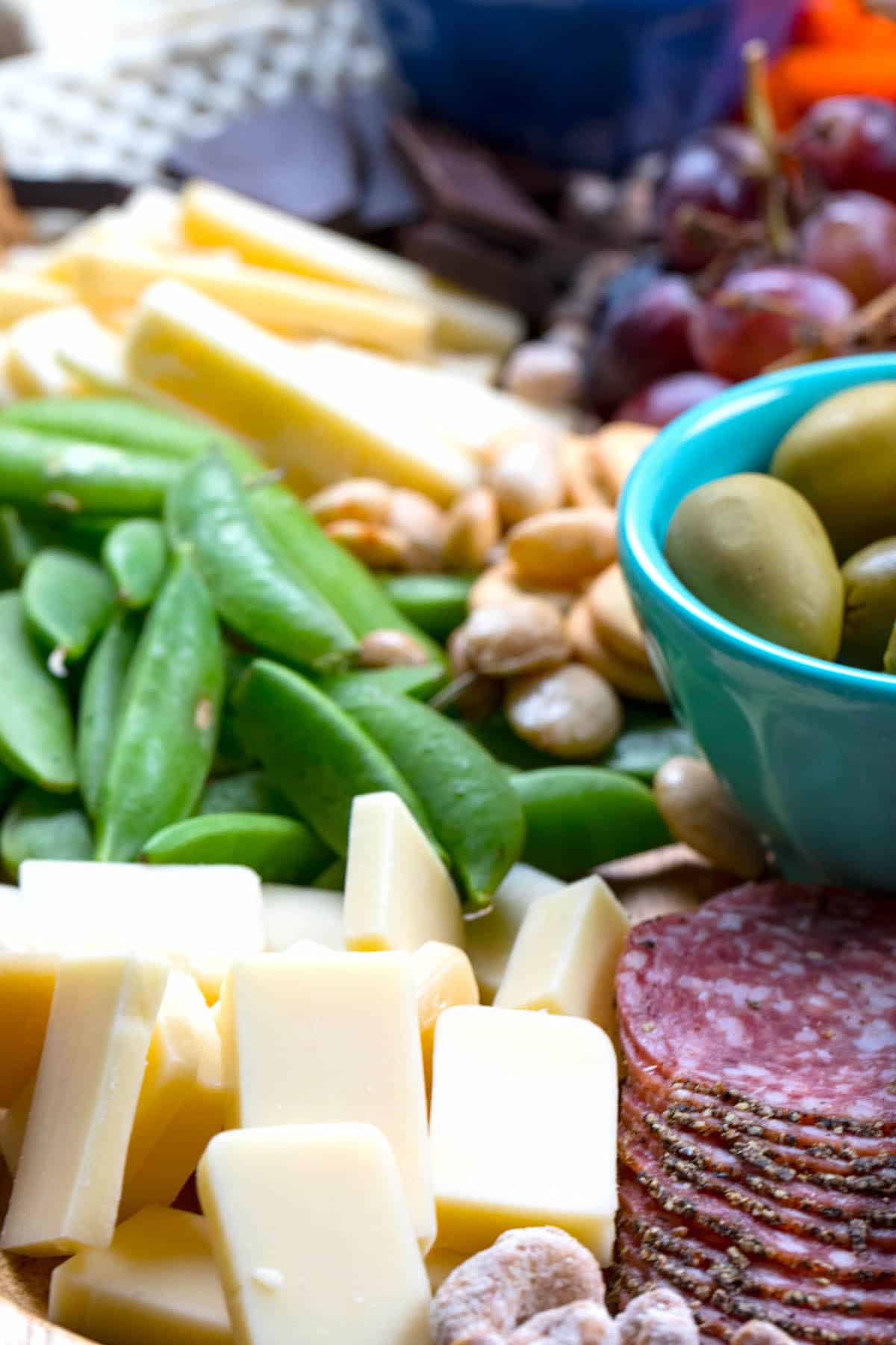 cheese board items laid on a wooden cutting board with words on top