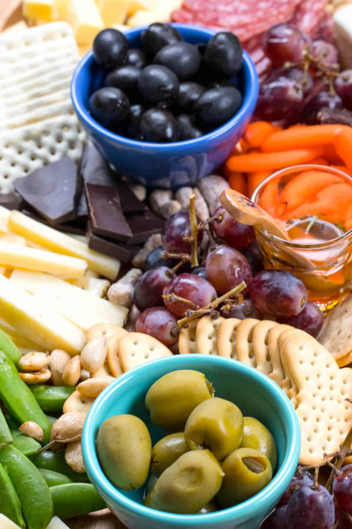 cheese board items laid on a wooden cutting board with words on top