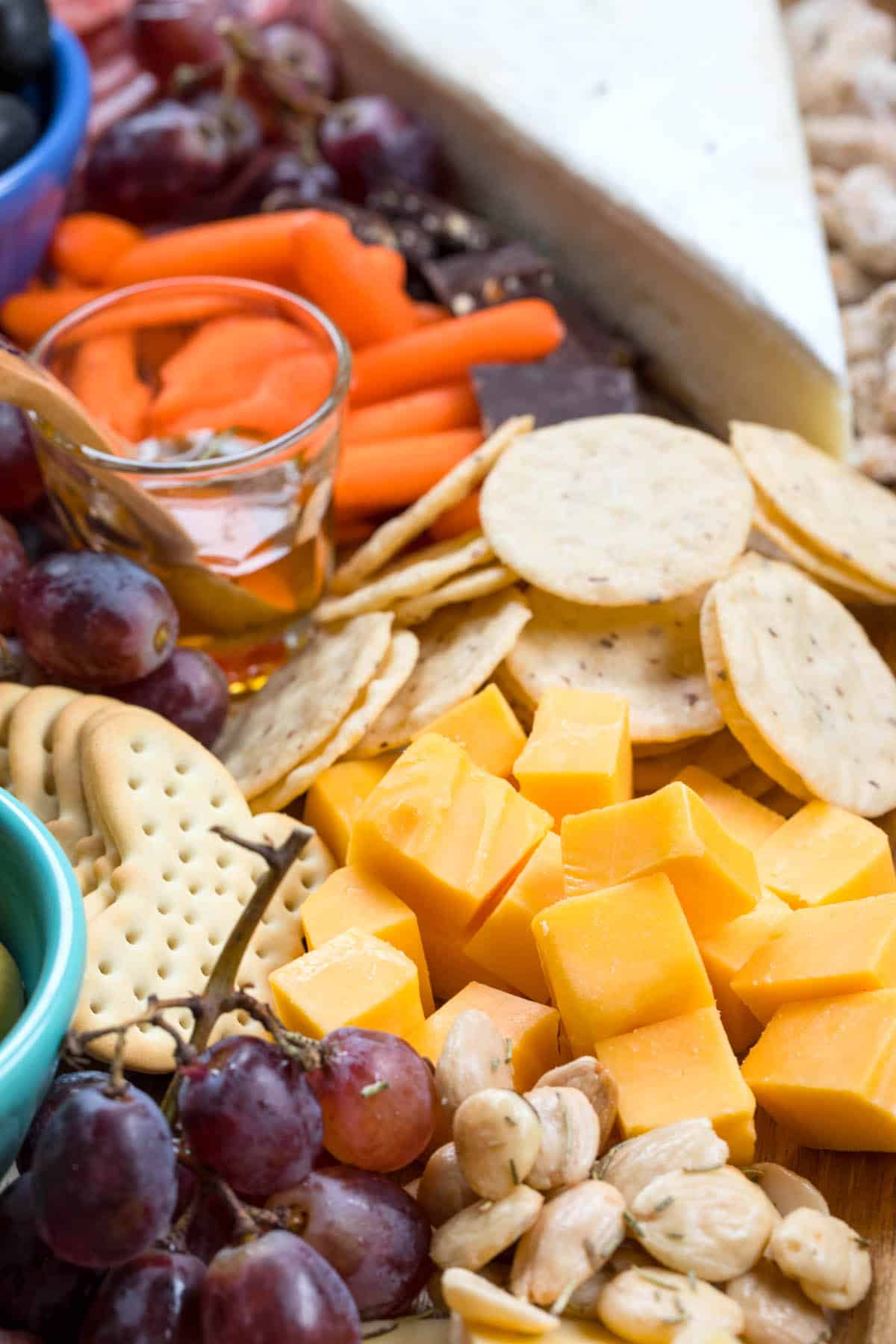 cheese board items laid on a wooden cutting board with words on top