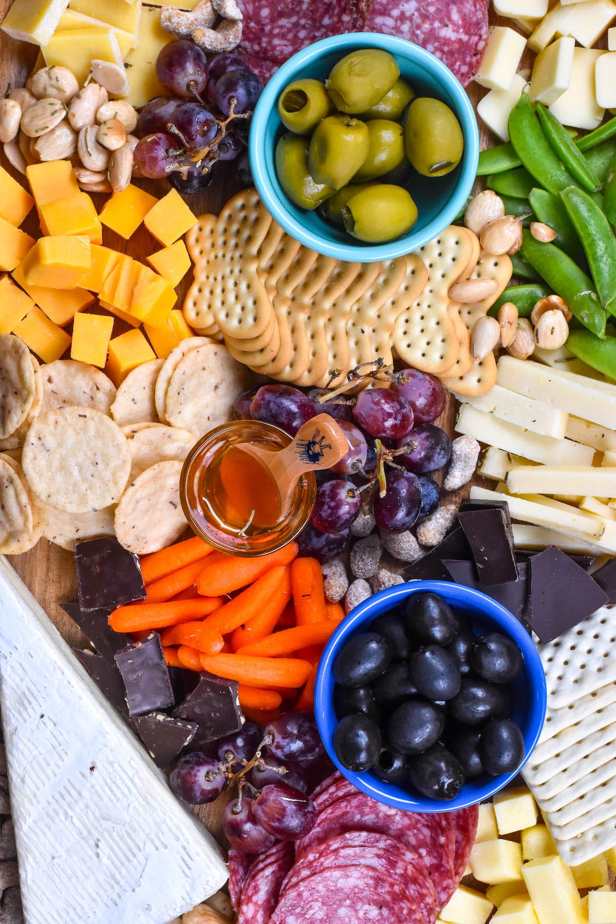 cheese board items laid on a wooden cutting board with words on top