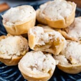 stack of mini pies on blue plate with one missing a bite