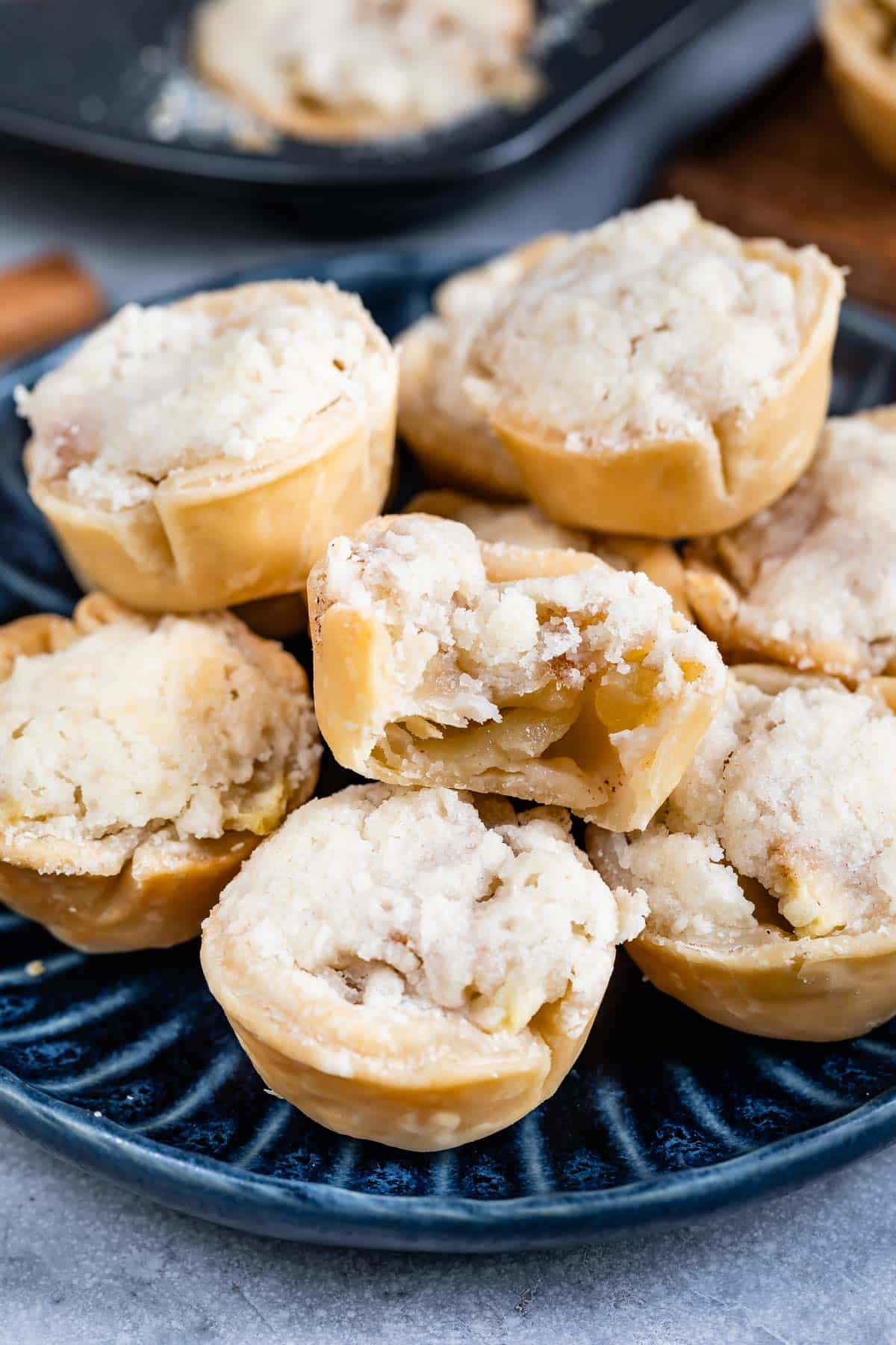 stack of mini pies on blue plate with one missing a bite