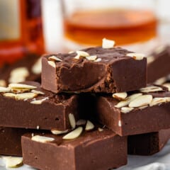 brown fudge with shaved almonds on top on a white plate