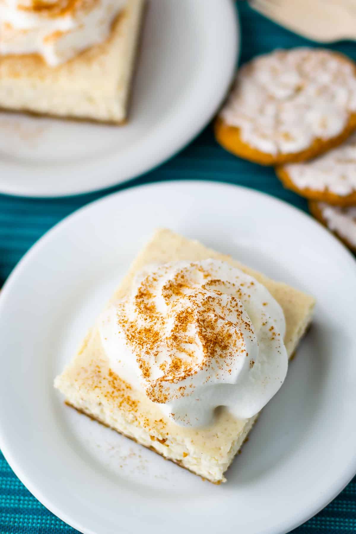 one square slice of cheesecake bars on a white plate with words on the photo saying the name of the recipe