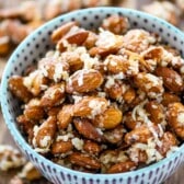 almonds in a blue and purple bowl covered in coconut shreds