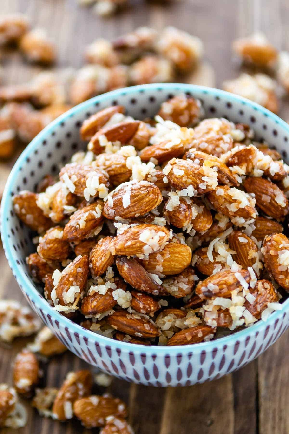 almonds in a blue and purple bowl covered in coconut shreds