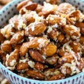 almonds in a blue and purple bowl covered in coconut shreds