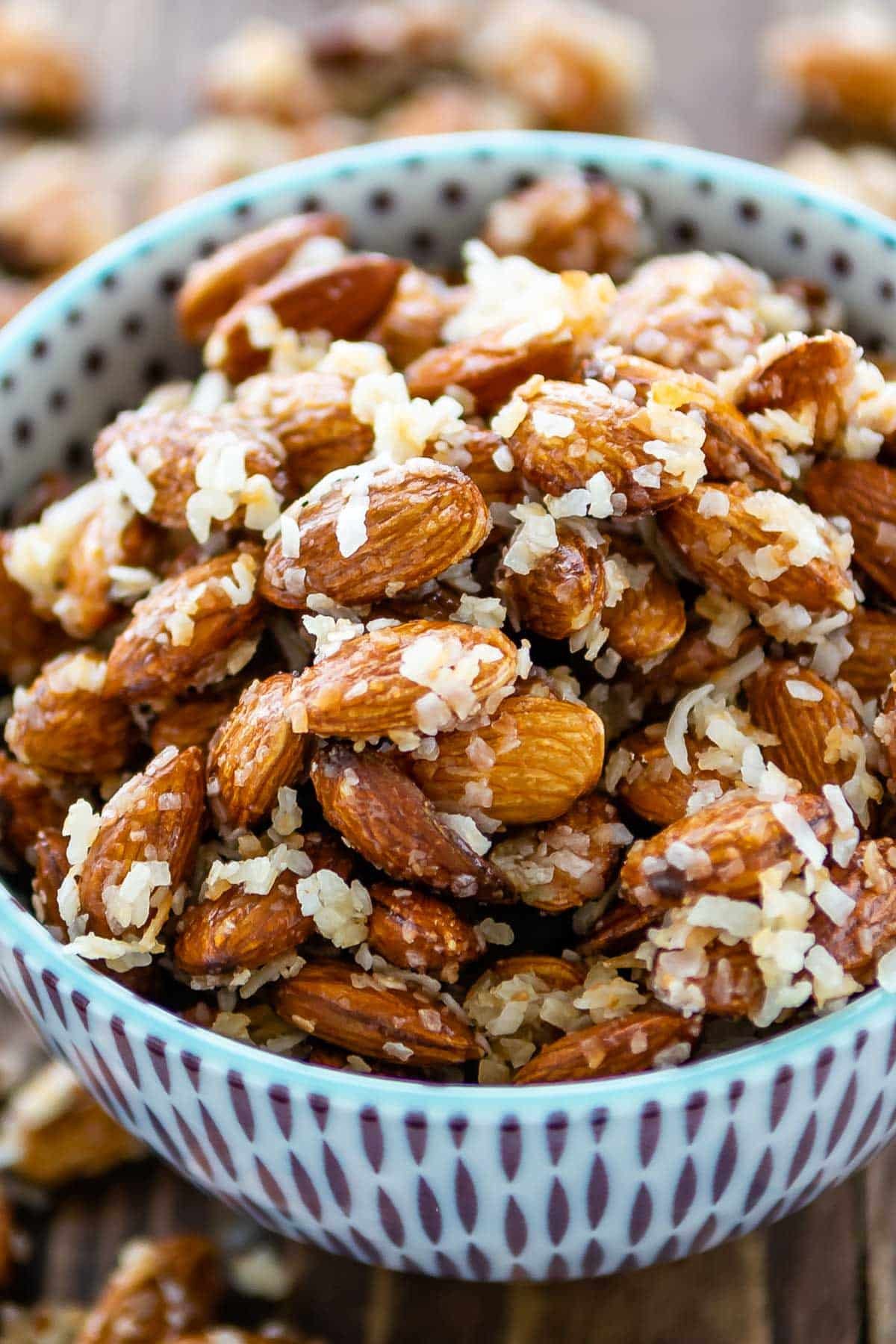 almonds in a blue and purple bowl covered in coconut shreds