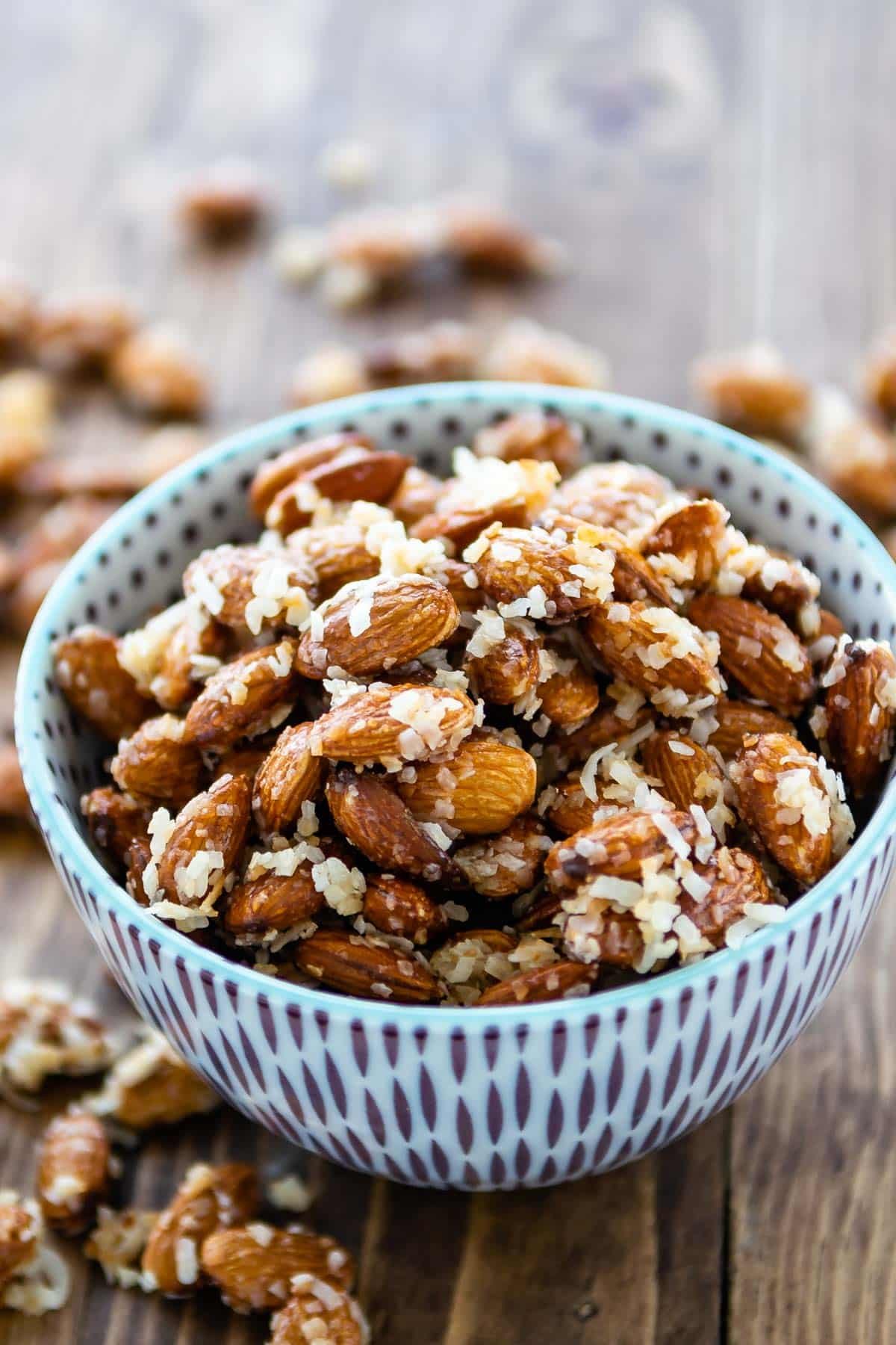 almonds in a blue and purple bowl covered in coconut shreds