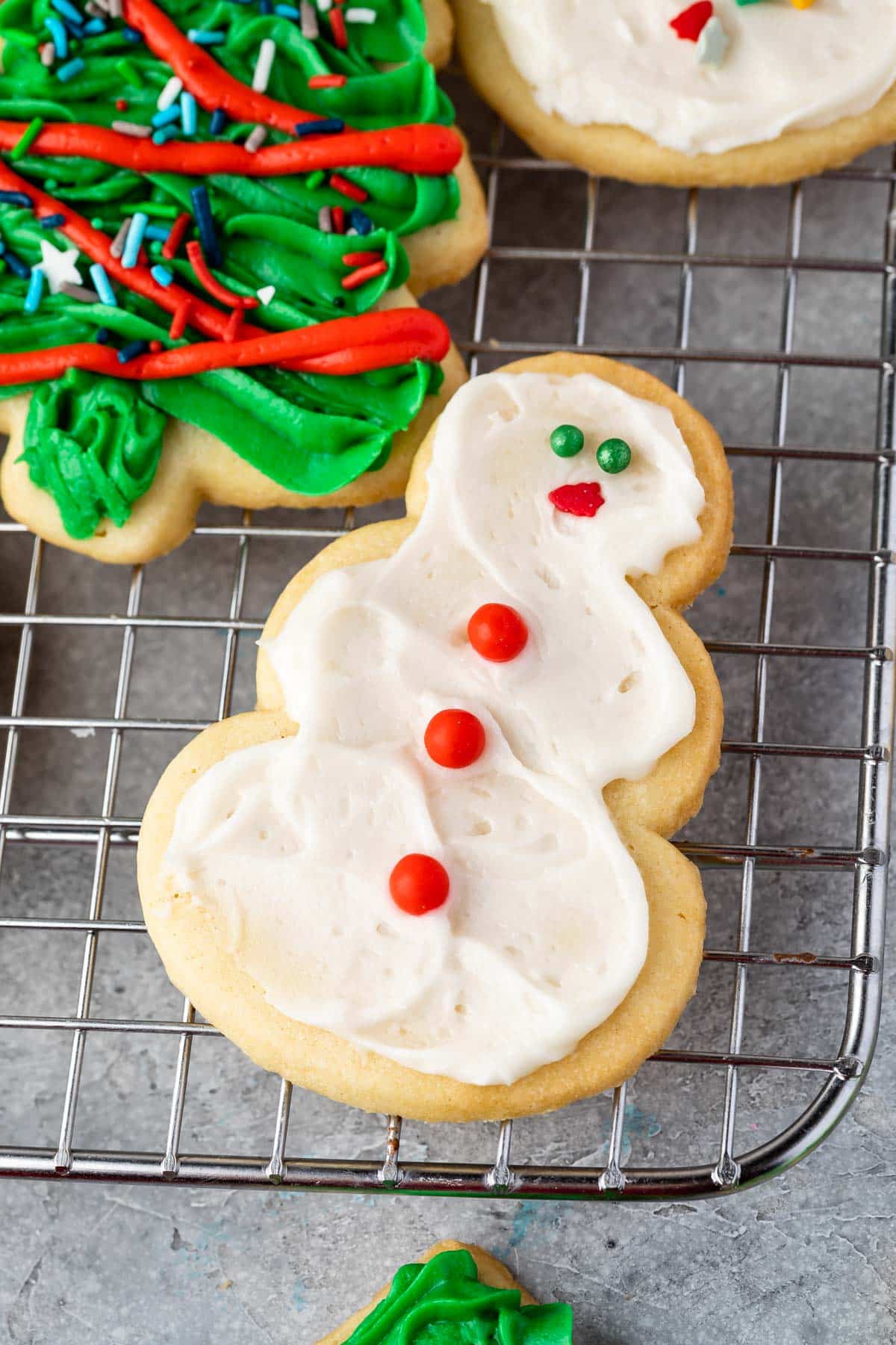 snowman shaped cookie decorated with frosting and sprinkles