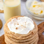 frosted eggnog cookies stacked on a cutting board