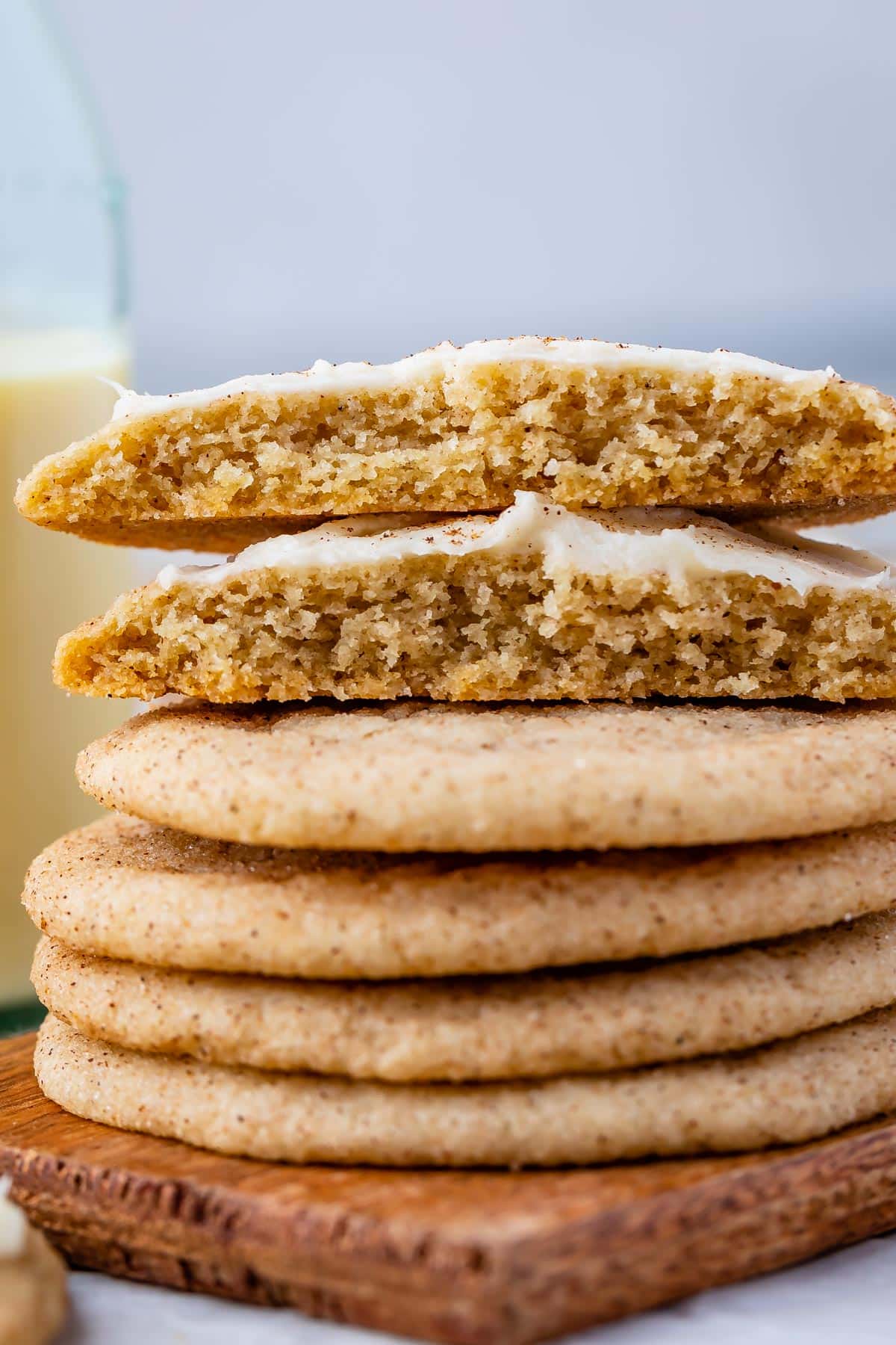 frosted eggnog cookies stacked on a cutting board