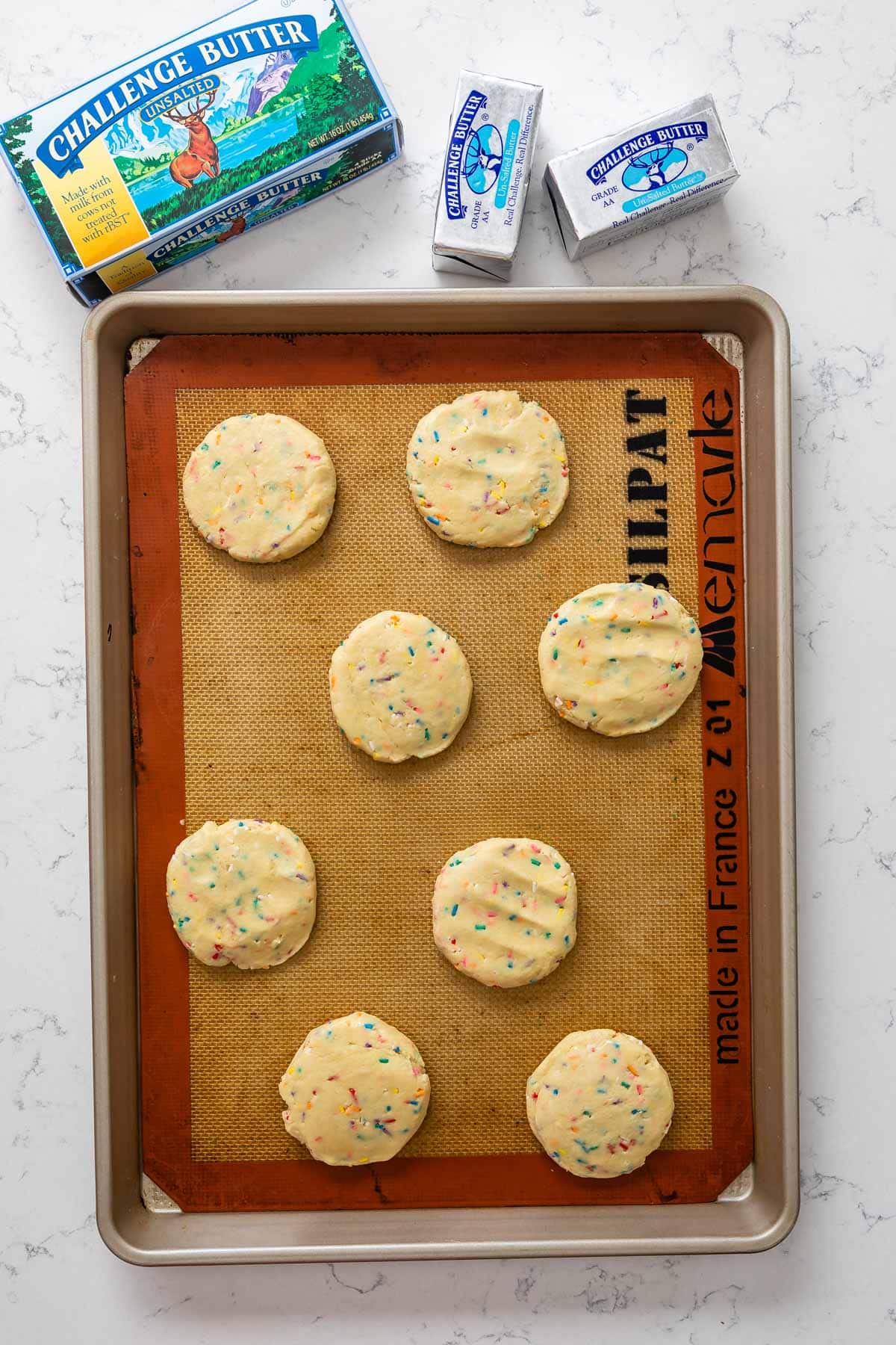 unbaked cookies on cookie sheet with butter box