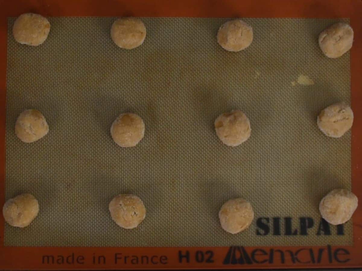 peanut butter cookie dough balls on silicone baking mat.