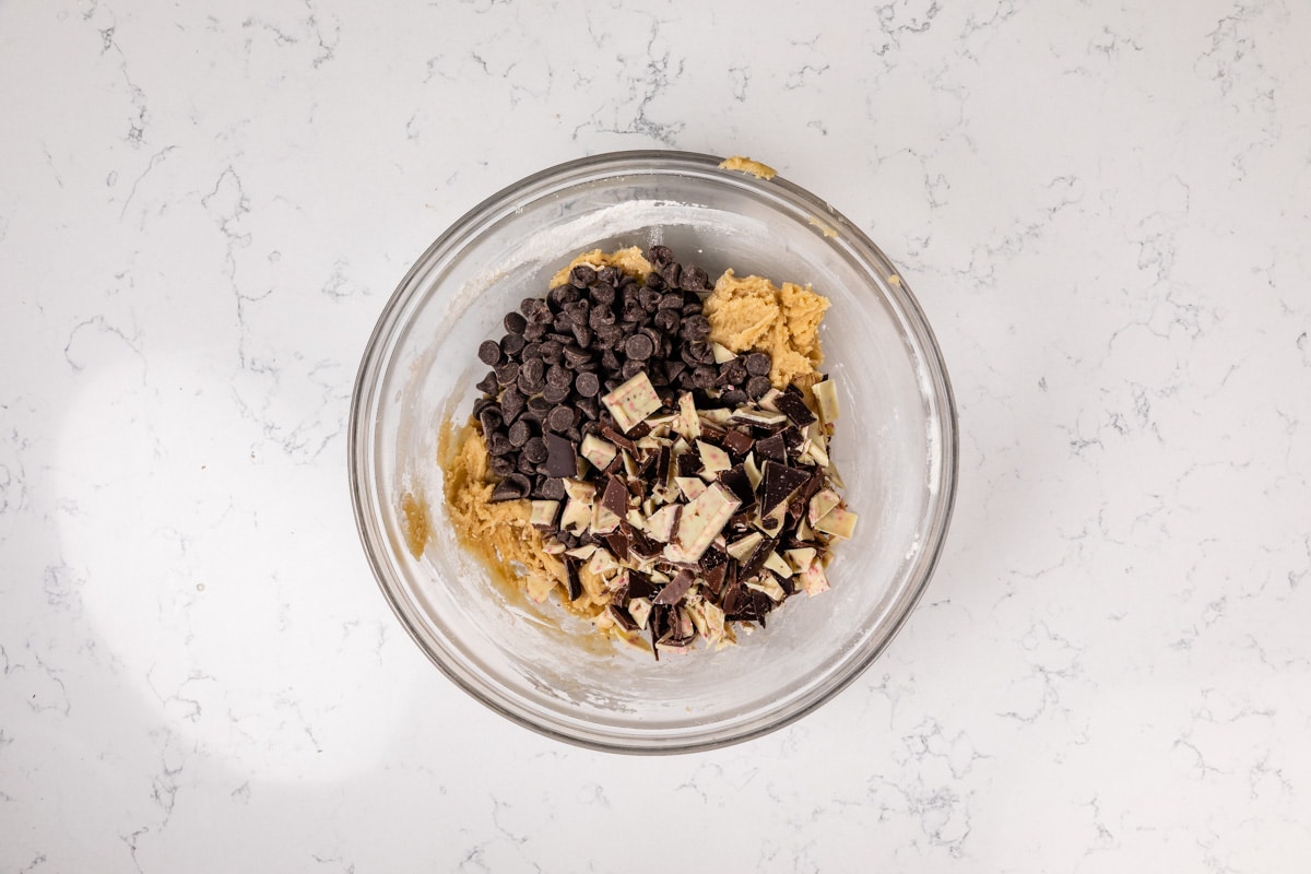 cookie dough with chocolate chips and peppermint bark pieces in bowl