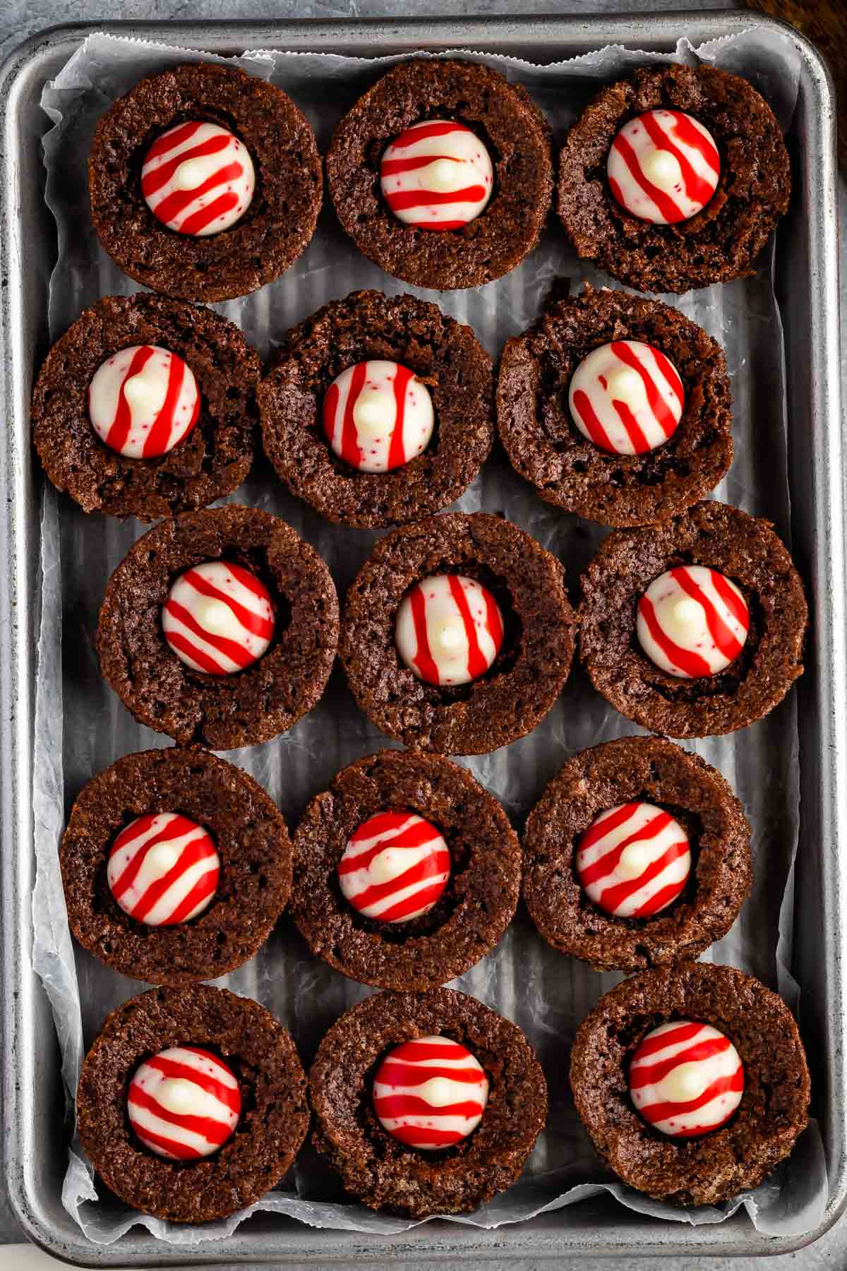 brownie bites laid out on a pan with a peppermint kiss in the middle