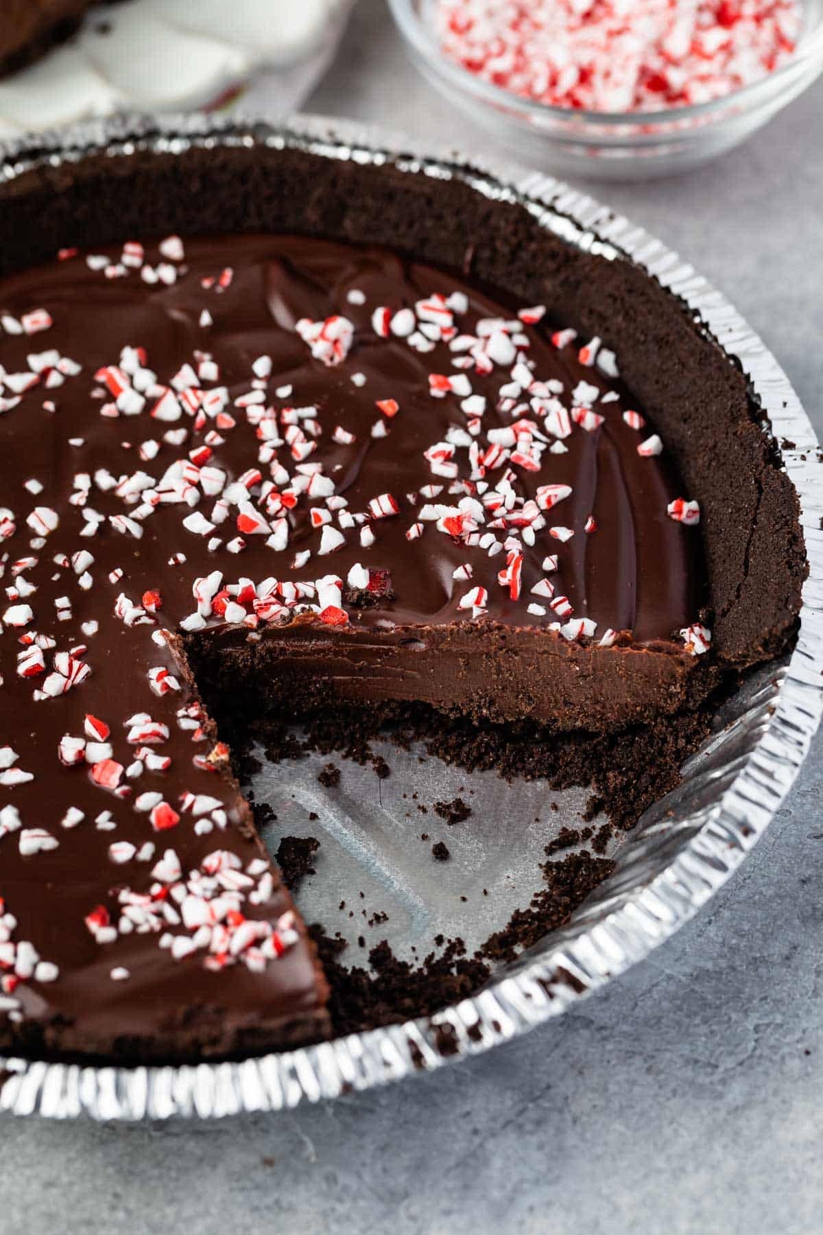 ganache pie in a pie tin with a slice taken out of the pan