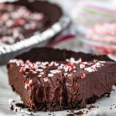 slice of ganache pie with crushed m&ms on top with a bite taken out of it