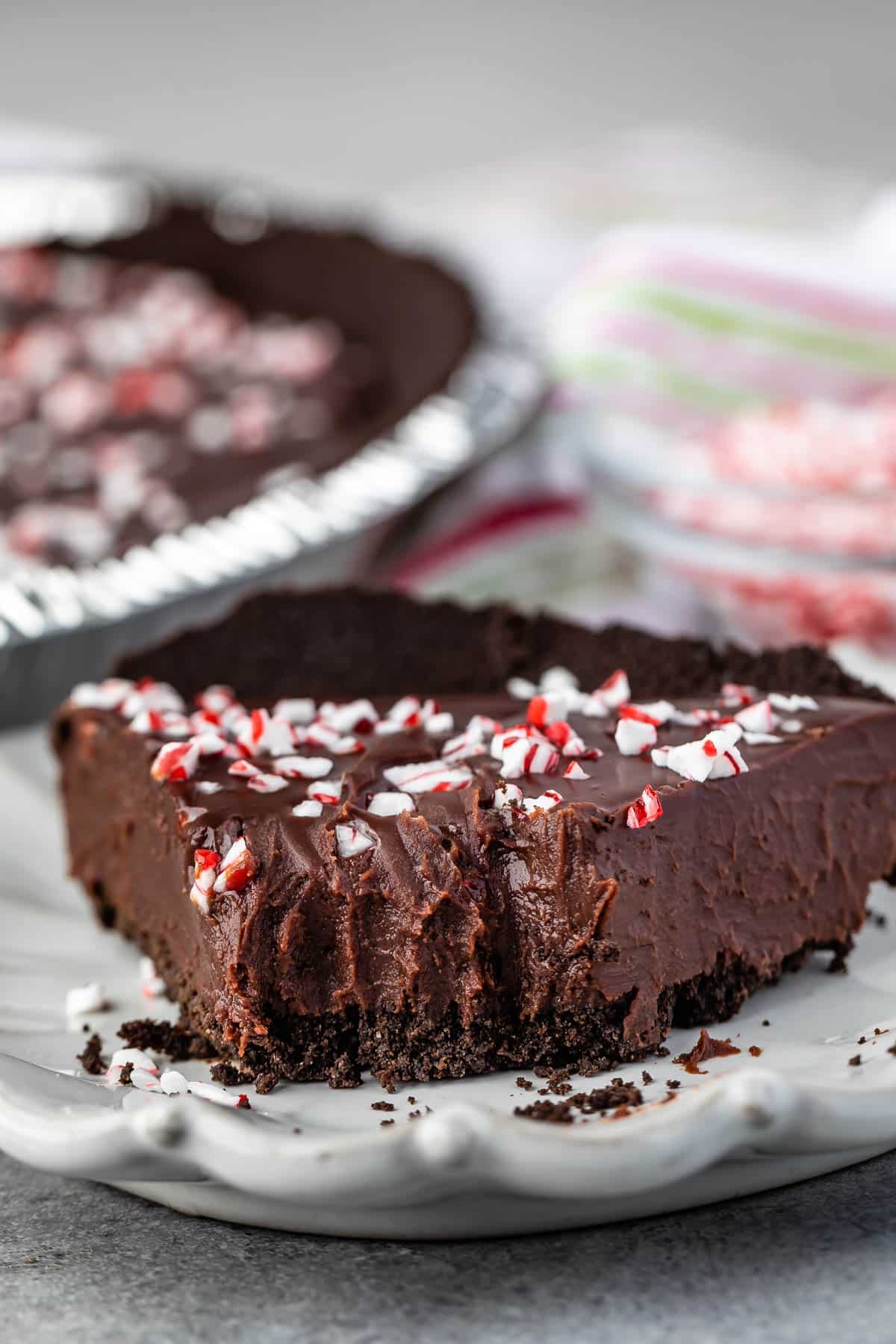 slice of ganache pie with crushed m&ms on top with a bite taken out of it