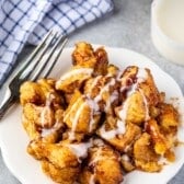 monkey bread covered in icing on a white plate